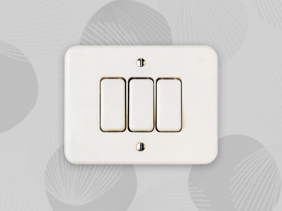 The BTicino Domino white wall plate features three rectangular switches set against a patterned gray background.