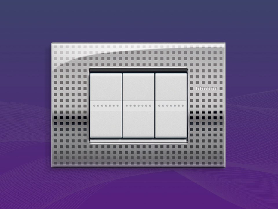 BTicino Livinglight metallic 3-module rectangular wall plate on a purple gradient background.