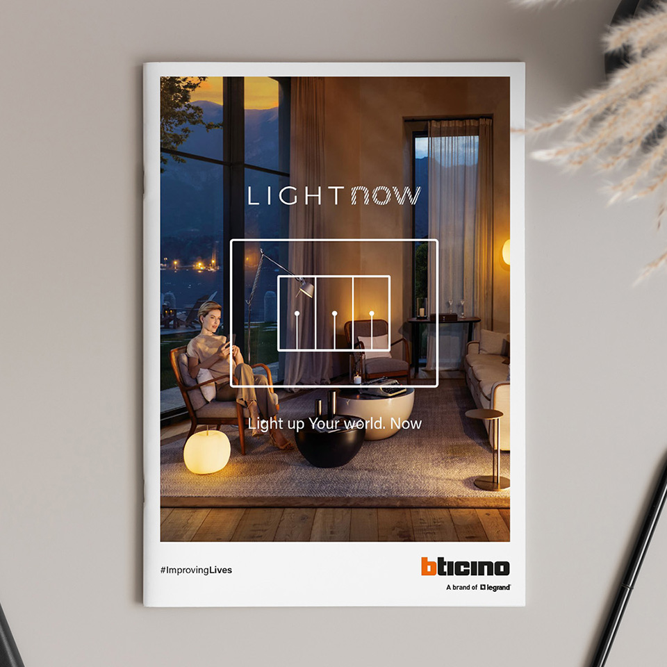 BTicino Light Now catalogue on a desk, featuring an elegant living room lit at dusk on the cover.