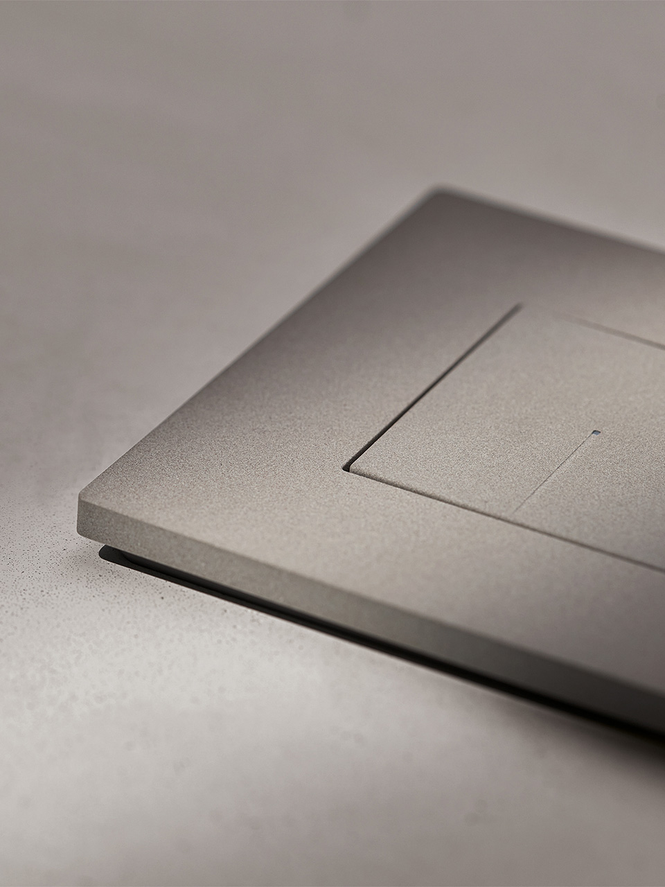 Close-up of BTicino Light Now light switch in sand stone color, on a grainy surface.