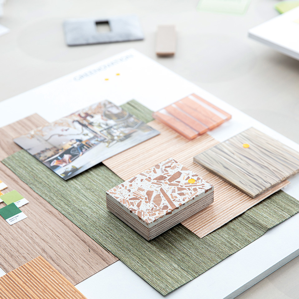 Assorted material samples, color swatches, and photos arranged on a tabletop for design or interior planning.
